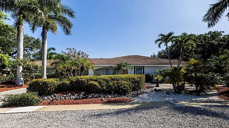 As you approach this lovely vacation home, lush greenery and shade trees...